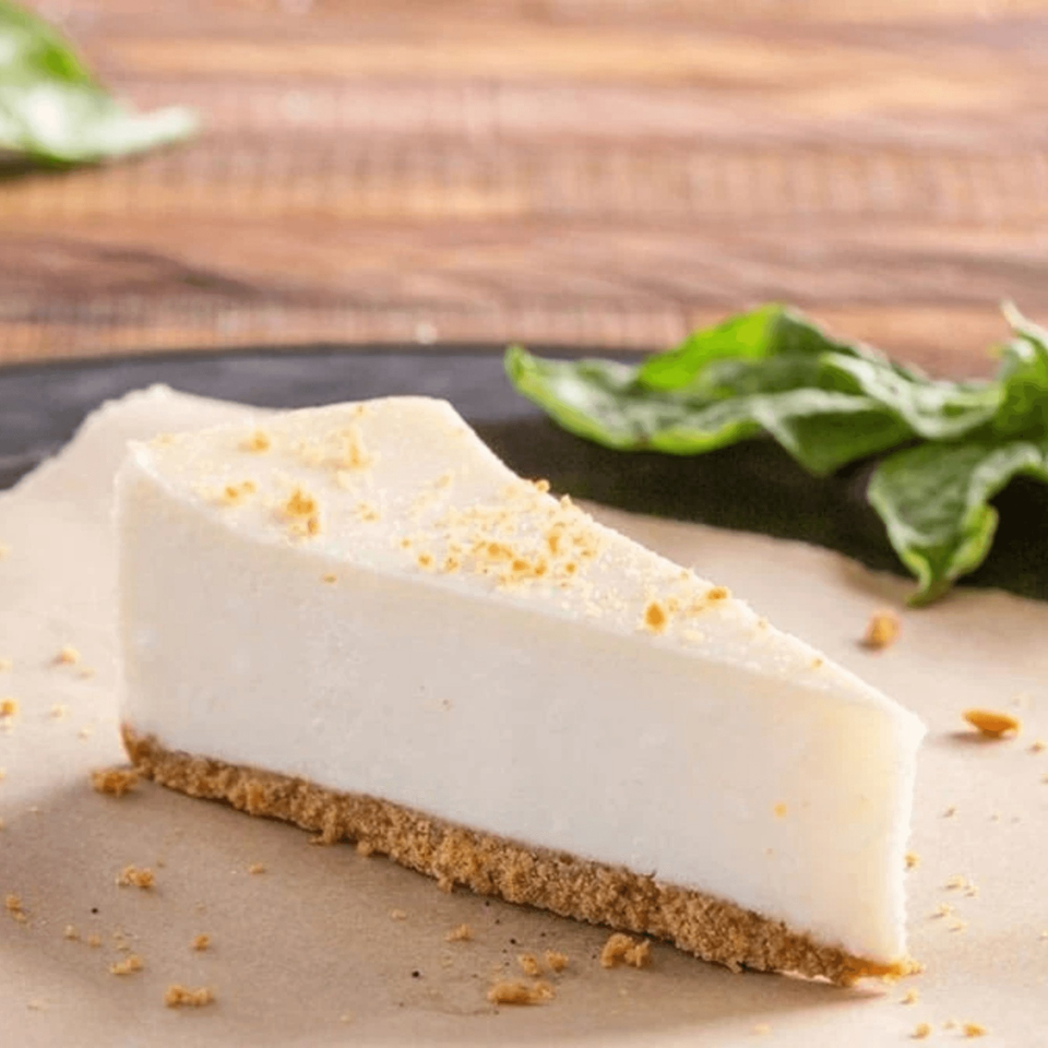 A slice of Ameci Pizza and Pasta Kitchen's cheesecake with a graham cracker crust and crumbs.